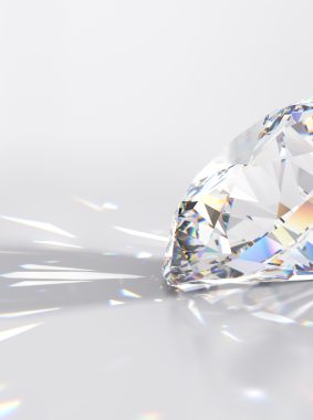 Side view of a round cut diamond with multi color caustics rays on light gray background